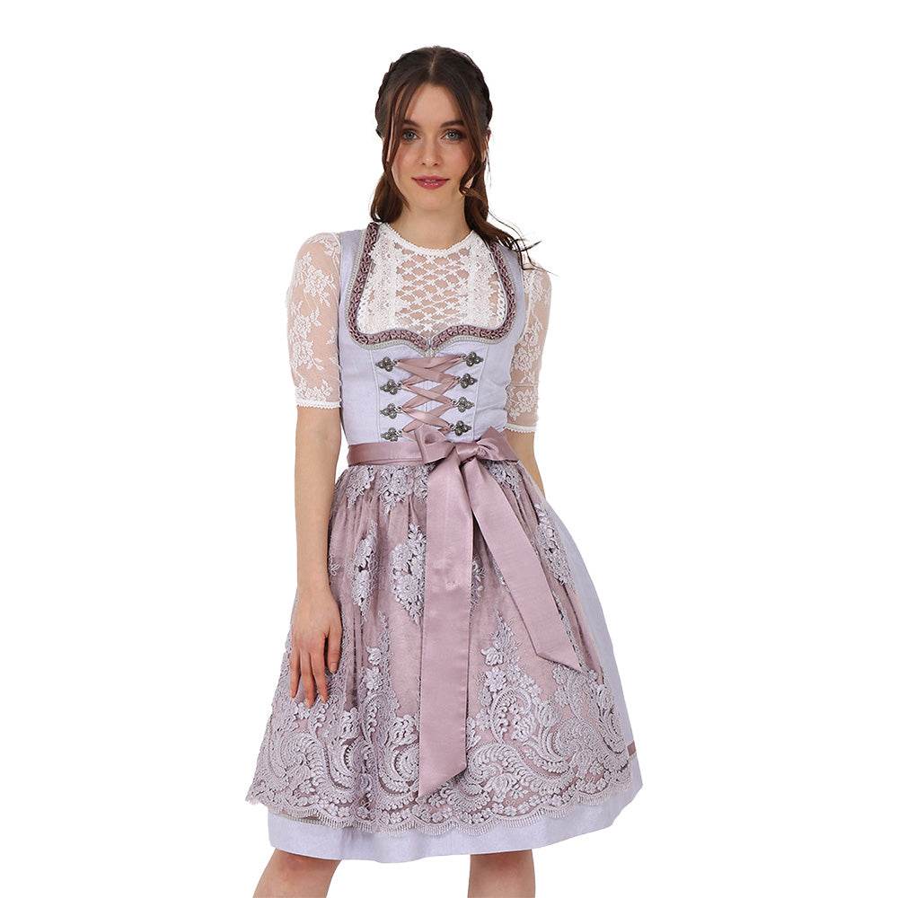 Zweiteiliges Dirndl in Grau mit Rosé- und Fliedertönen, herzförmigem Miederausschnitt, mittigem Reißverschluss und Schnürung; der Rock mit einheitlichem Muster und darüber eine zarte Spitzenschürze mit farblich abgestimmtem Unterstoff.