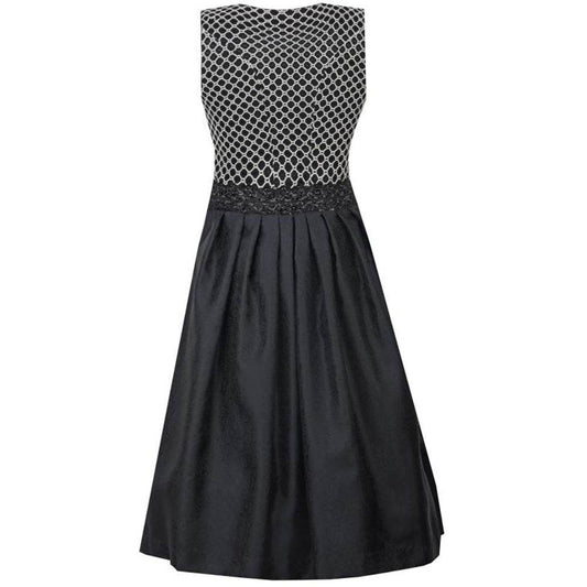 Zweiteiliges Dirndl in schwarz-creme mit Jacquard-Mieder im Rautenmuster, gepaspelten Ausschnitten und Reißverschluss vorne. Schwarzer Rock mit feinem Ornamentmuster, schwarze geraffte Schürze mit perlenverziertem Band und zwei verschließbaren Reißverschlusstaschen.