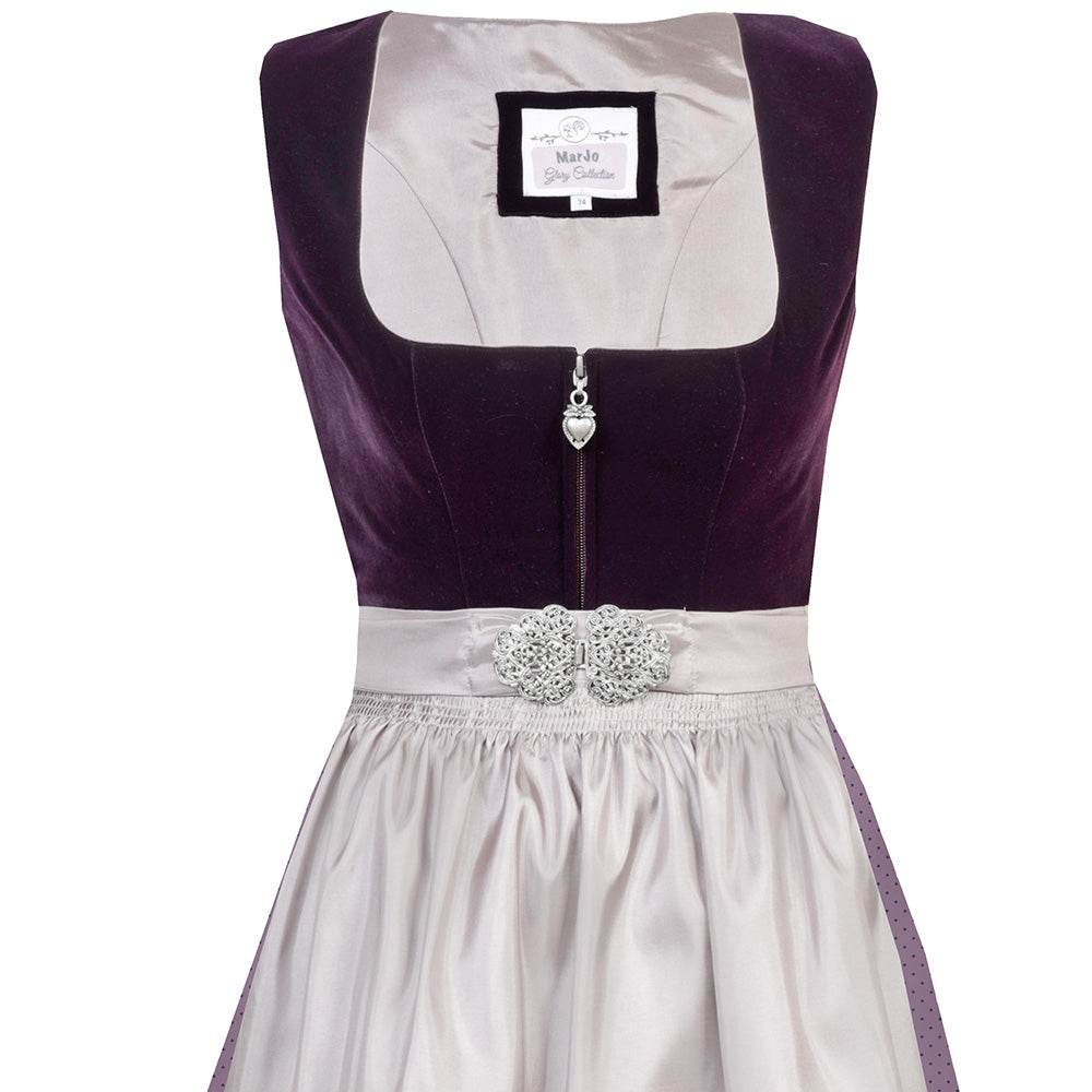 Elegantes Dirndl mit schlichtem Samtmieder in pflaumenfarbe und Reißverschluss mit Herzanhänger. Der Rock ist zart gepunktet, die mauvefarbene Schürze wird durch eine dekorative Schließe ergänzt.