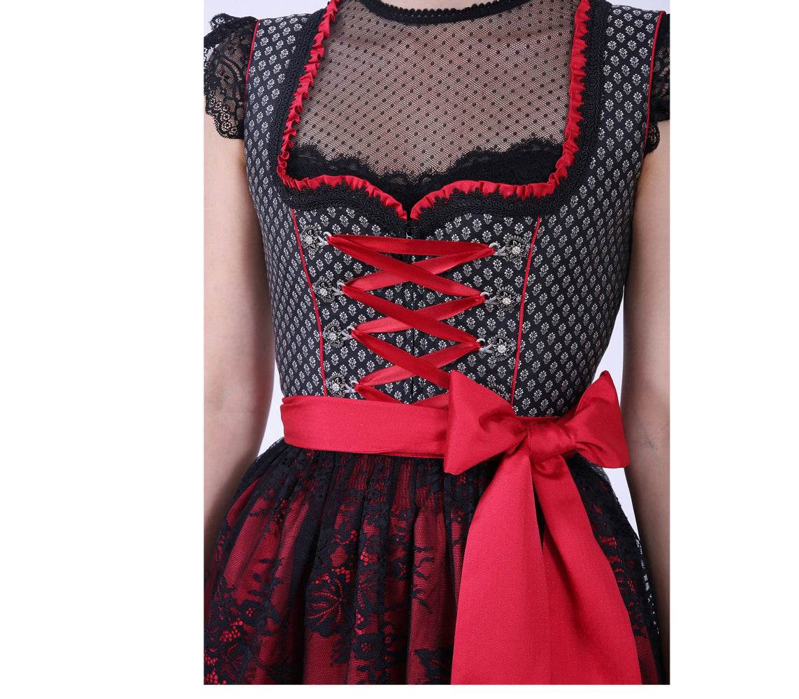 Elegantes Dirndl mit herzförmigem Mieder, mittigem Reißverschluss und passender Schnürung, einheitlichem Muster und Spitzenschürze mit rotem Kontraststoff.