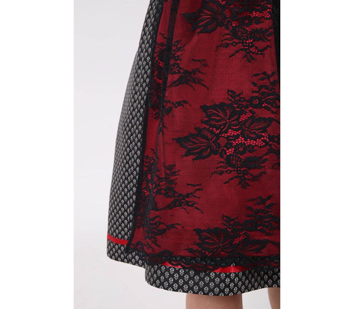 Elegantes Dirndl mit herzförmigem Mieder, mittigem Reißverschluss und passender Schnürung, einheitlichem Muster und Spitzenschürze mit rotem Kontraststoff.