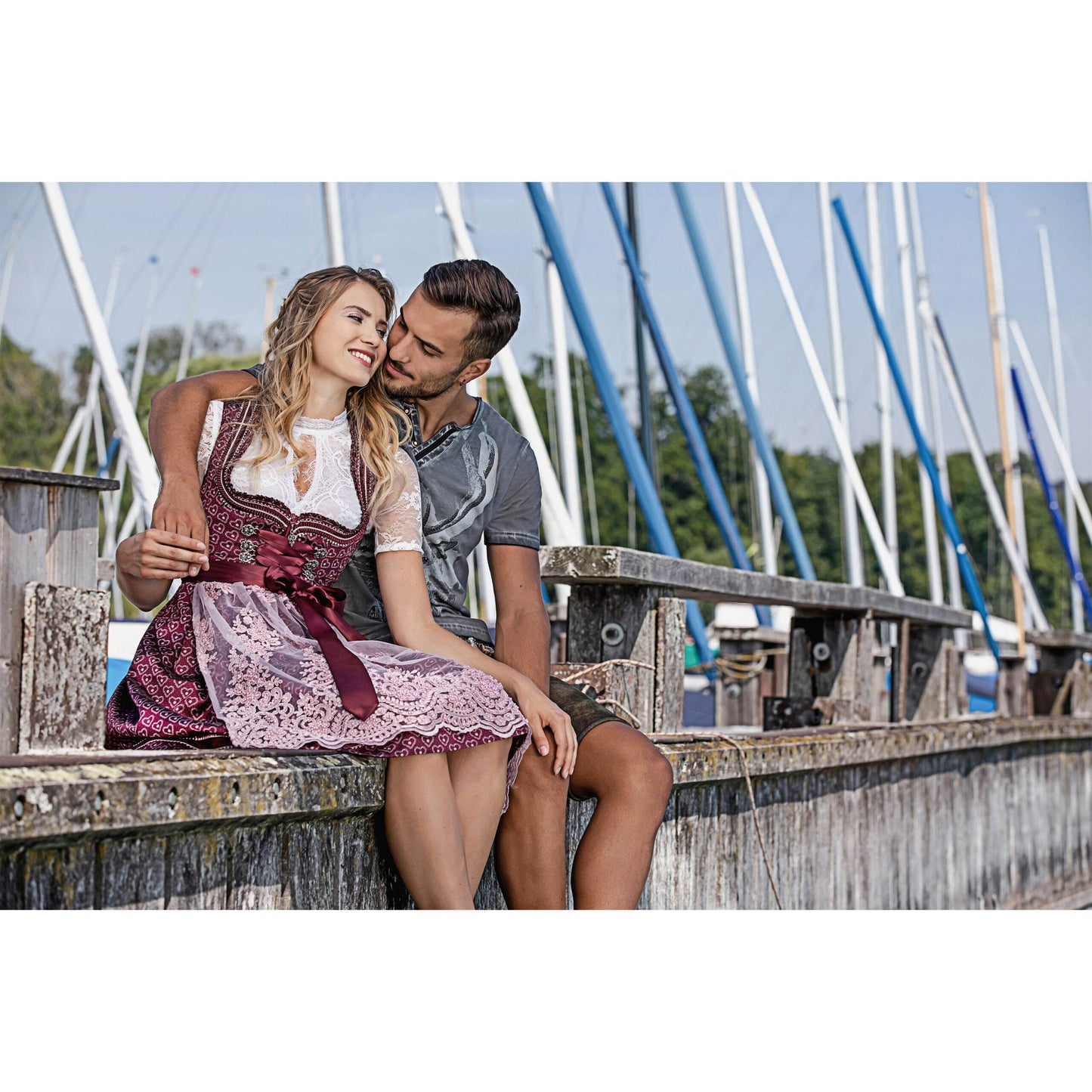 Modernes Dirndl in Beere mit Herzmuster, rosa Spitzen-Schürze, Mieder mit Reißverschluss, Schnürung und verziertem Ausschnitt.