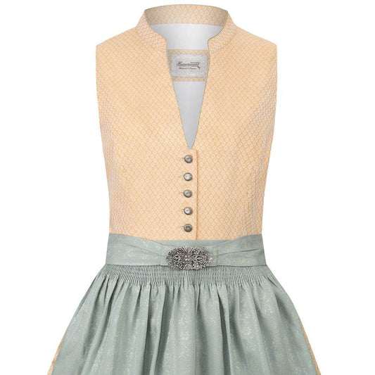 Klassisches gelbes Dirndl mit hochgeschlossenem Schnitt, V-Ausschnitt mit dekorativen Knöpfen, fein gemustertem Stoff und unifarbener Schürze mit Metallschließe.