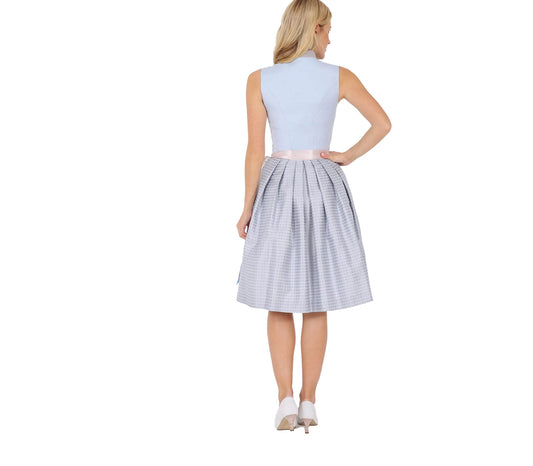 Klassisches Dirndl mit dezentem Muster am Rock, hochwertigen Knöpfen am Mieder, farblich abgestimmter Schürze und kurzem Stehkragen am Ausschnitt.