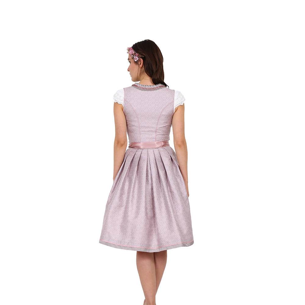 Zweiteiliges Dirndl in Beige-Rosé mit herzförmigem Mieder, mittigem Reißverschluss und Schnürung, dezentem Muster im Hauptstoff, unifarbener Schürze und Rüschen am Ausschnitt.