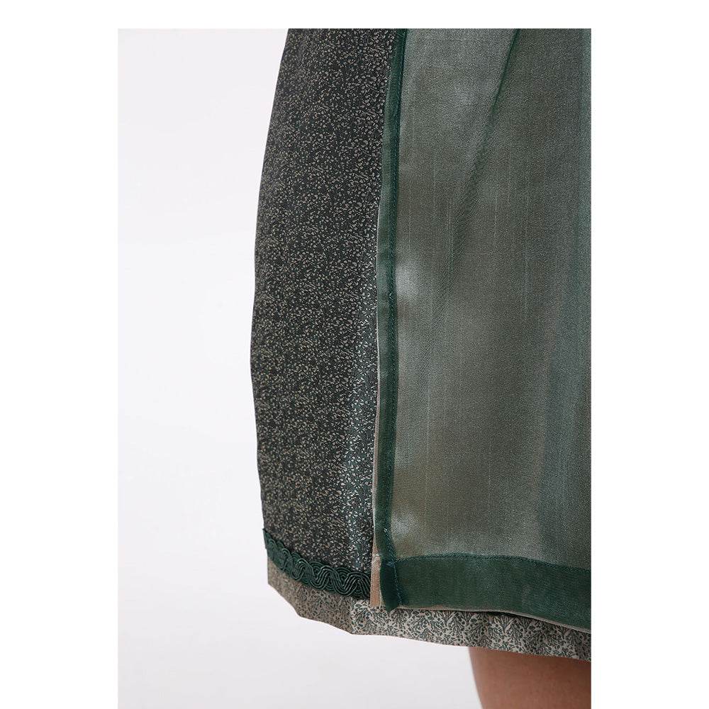 Zweiteiliges Dirndl in Dunkelgrün mit besonderem Mieder ohne Schnürung und mittigem Reißverschluss, Rock mit feinem Ornamentenmuster und schlichter, transparenter Organzaschürze mit unterlegtem Kontraststoff.