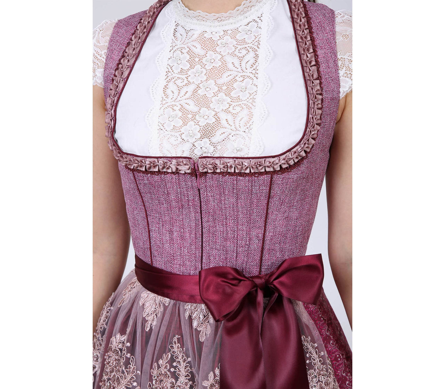 Elegantes pinkes Dirndl mit Mieder ohne Schnürung und mittigem Reißverschluss, Rock mit Ornamentenmuster und reich verzierte Spitzenschürze mit Kontraststoff.