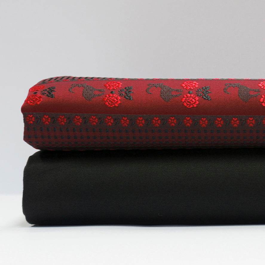 Schwarzer Baumwollsatin für Oberteil und Rock, dazu eine Schürze mit Muster aus Steinbock und Blümchen in Rot, Schwarz, Weiß und Gelb.