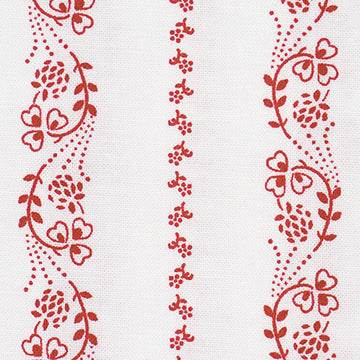 Stoffmuster für Dirndl mit kleinen roten und weißen Blumen auf Oberteilstoff, weiße Schürze mit roten Blümchen und dunkelblauer Rockstoff mit weißem Hirschmuster.