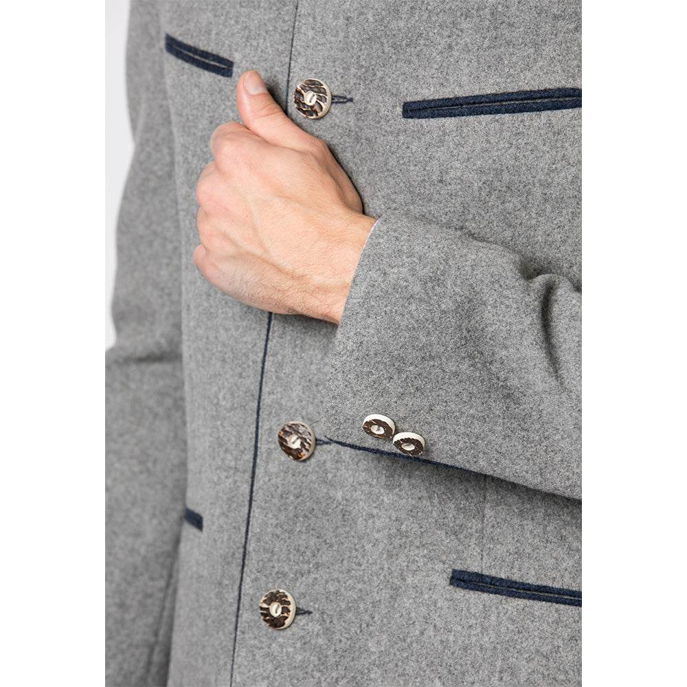 Trachtenjacke im melierten Loden-Look mit geradem Schnitt, besticktem Stehkragen, Paspel und rustikalen Hornknöpfen, hinten mit klassischer Kellerfalte, im traditionellen Trachtenstil.