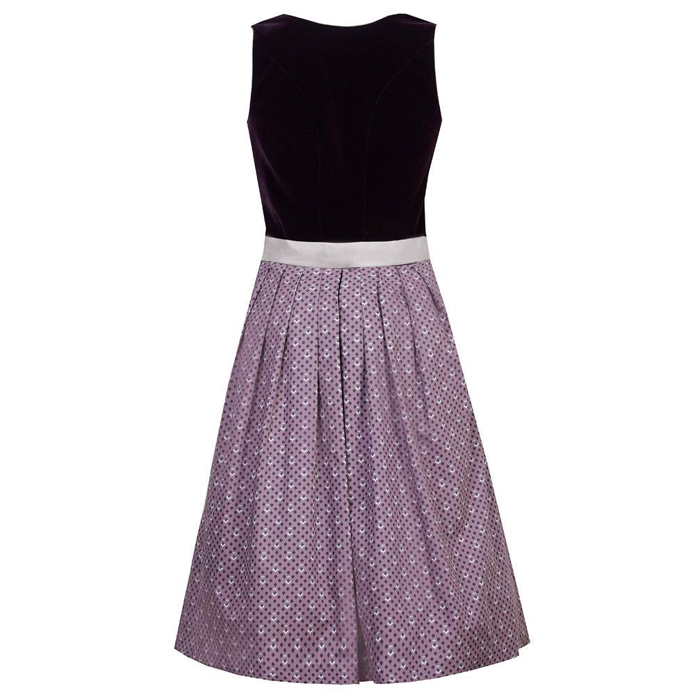 Elegantes Dirndl mit schlichtem Samtmieder in pflaumenfarbe und Reißverschluss mit Herzanhänger. Der Rock ist zart gepunktet, die mauvefarbene Schürze wird durch eine dekorative Schließe ergänzt.