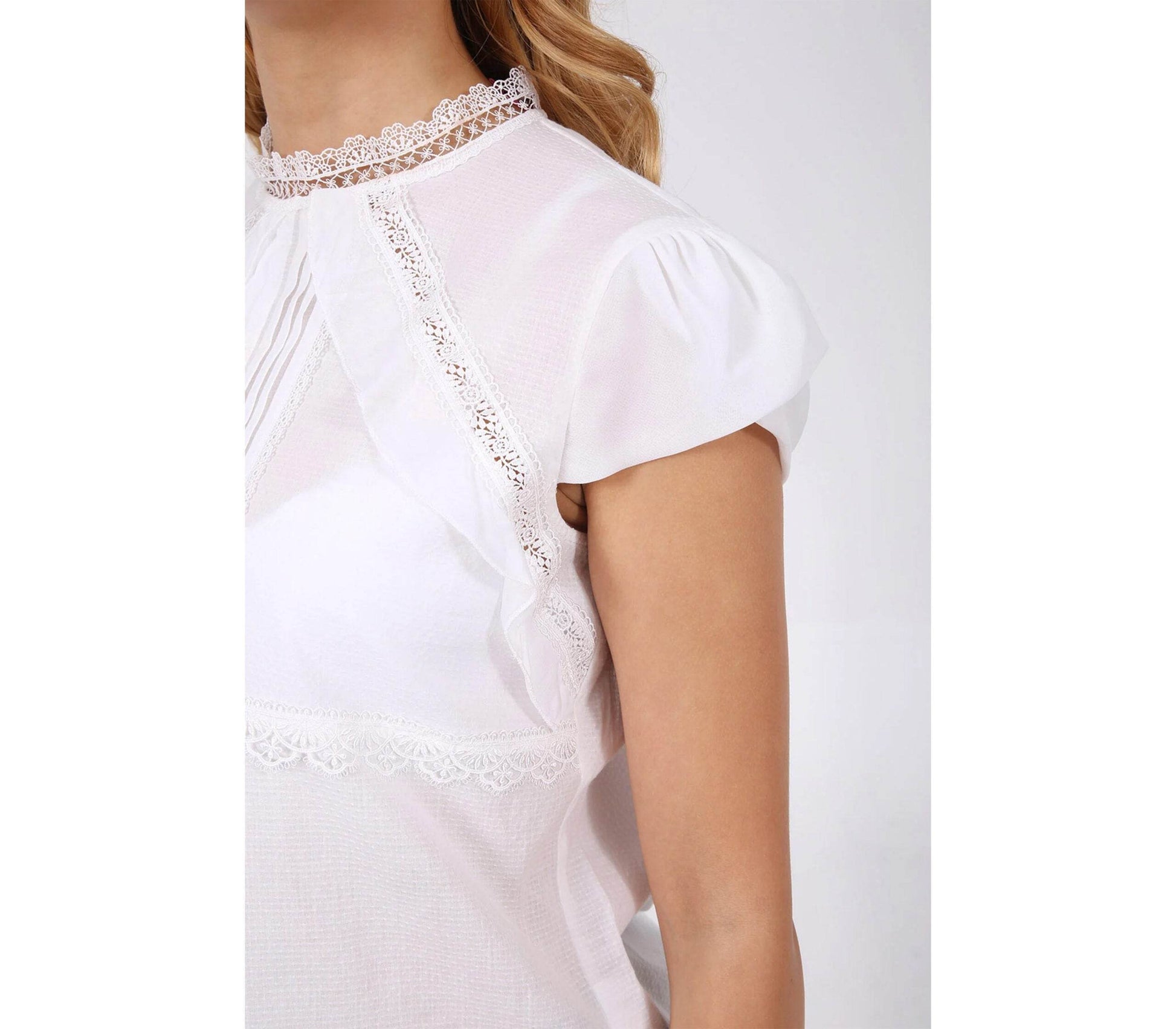 Hochgeschlossene ecru Bluse mit feinen Rüschen an der Vorderseite, langärmelig und elegant geschnitten. Schlichter, zeitloser Look.