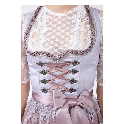 Zweiteiliges Dirndl in Grau mit Rosé- und Fliedertönen, herzförmigem Miederausschnitt, mittigem Reißverschluss und Schnürung; der Rock mit einheitlichem Muster und darüber eine zarte Spitzenschürze mit farblich abgestimmtem Unterstoff.
