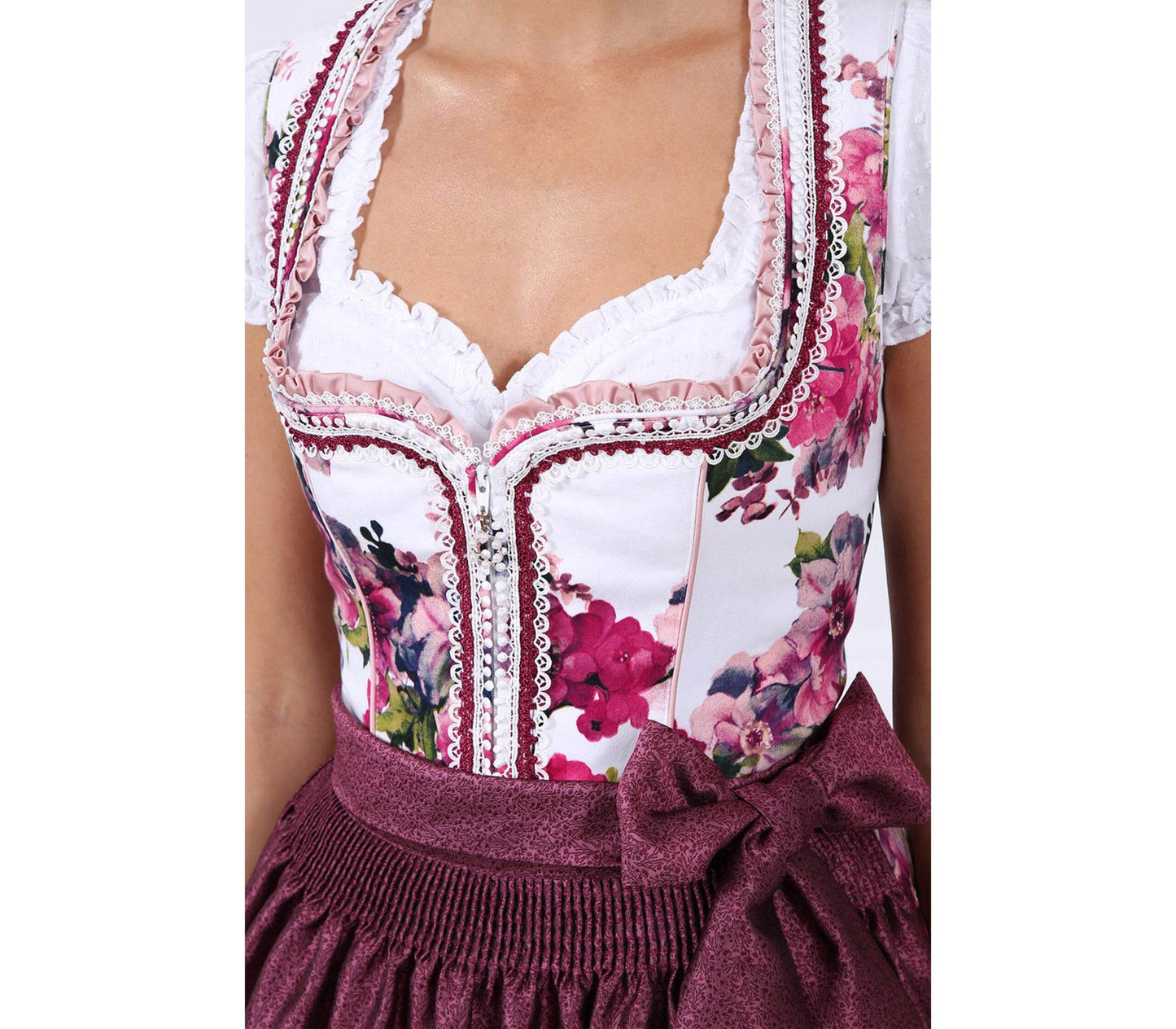 Pinkes Dirndl mit herzförmigem Mieder, mittigem Reißverschluss und floralem Muster, dazu passende Schürze mit gleichen Blumenmotiven, romantisch und frühlingshaft.