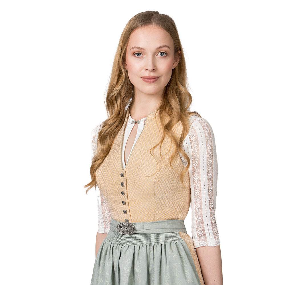 Klassisches gelbes Dirndl mit hochgeschlossenem Schnitt, V-Ausschnitt mit dekorativen Knöpfen, fein gemustertem Stoff und unifarbener Schürze mit Metallschließe.