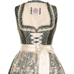 Modernes Dirndl in Smaragd mit Ornamentenmuster, cremefarbener Spitzenschürze, Mieder mit Reißverschluss, Schnürung und verziertem Ausschnitt.