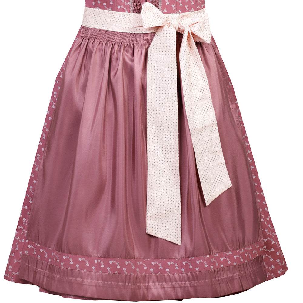 Nettes Dirndl in canberry-Farbe mit liebevollem Blumenmuster, Satinschürze mit Musterwiederholung und einem dekorativen Schleifenband. Das Mieder zeigt einen Reißverschluss, der Ausschnitt ist aufwendig verziert.