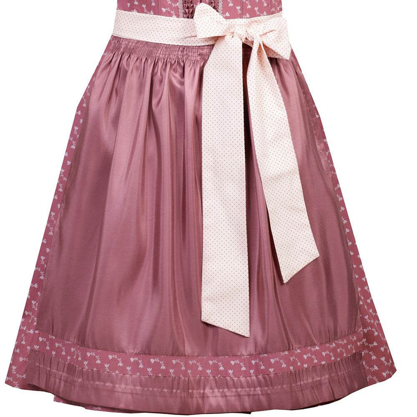 Nettes Dirndl in canberry-Farbe mit liebevollem Blumenmuster, Satinschürze mit Musterwiederholung und einem dekorativen Schleifenband. Das Mieder zeigt einen Reißverschluss, der Ausschnitt ist aufwendig verziert.