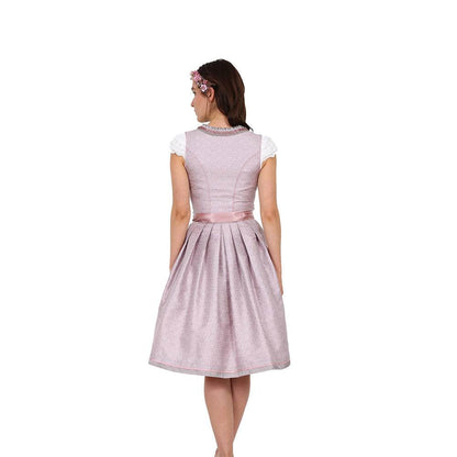 Zweiteiliges Dirndl in Beige-Rosé mit herzförmigem Mieder, mittigem Reißverschluss und Schnürung, dezentem Muster im Hauptstoff, unifarbener Schürze und Rüschen am Ausschnitt.