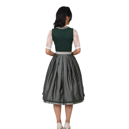 Zweiteiliges Dirndl in Dunkelgrün mit besonderem Mieder ohne Schnürung und mittigem Reißverschluss, Rock mit feinem Ornamentenmuster und schlichter, transparenter Organzaschürze mit unterlegtem Kontraststoff.