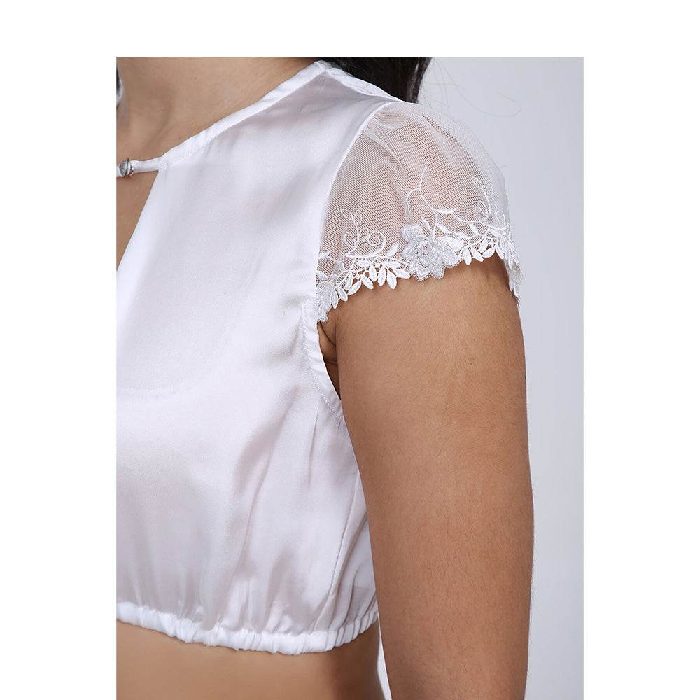 Klassische Dirndlbluse in Ecru mit seidigem Glanz, Lochausschnitt mit dekorativer Schließe und halbtransparenten Flügelärmeln aus Spitze.