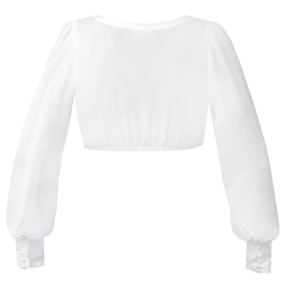 Dirndlbluse in Off-White mit langen, voluminösen Puffärmeln aus transparentem Chiffon, V-Ausschnitt und durchgehender Knopfleiste. Die Ärmel enden in breiten, geknöpften Manschetten mit feinen Details.