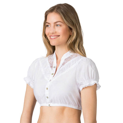 Weiße Dirndlbluse im klassischen Stil mit kleinem Stehkragen, durchgehender Knopfleiste sowie feinen Spitzen und dekorativen Borten am Stoff.