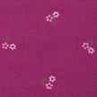 Stoffmuster für Dirndl mit Trachtenstoff in Fuchsia und Weiß mit kleinen Hirschen und Blumen für Erwachsene, kindliches Blümchenmuster in Pink und Grün sowie Schürze mit mehrfarbigem Blümchenjacquard in Weiß, Fuchsia, Blau und Lila.