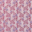 Stoffmuster für Dirndl mit Trachtenstoff in Fuchsia und Weiß mit kleinen Hirschen und Blumen für Erwachsene, kindliches Blümchenmuster in Pink und Grün sowie Schürze mit mehrfarbigem Blümchenjacquard in Weiß, Fuchsia, Blau und Lila.