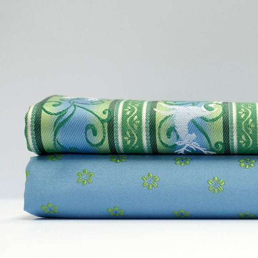 Stoffmuster für Dirndl mit hellblau-grünem Blümchenjacquard für Oberteil und Rock, dazu längsgestreifte Schürze mit grün-blauem Hirschmuster.