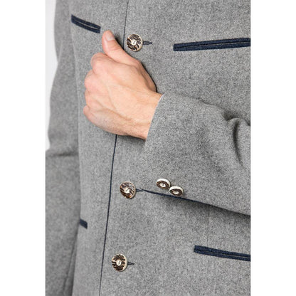 Trachtenjacke im melierten Loden-Look mit geradem Schnitt, besticktem Stehkragen, Paspel und rustikalen Hornknöpfen, hinten mit klassischer Kellerfalte, im traditionellen Trachtenstil.